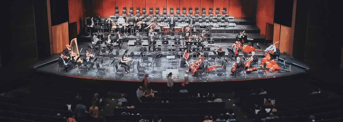 Orchestra performing on stage with audience